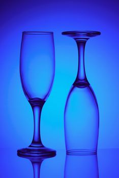 Two empty glasses in blue light