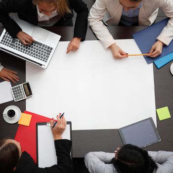 Business workplace with people, cup of coffee, digital tablet, smartphone, papers and various office objects on table