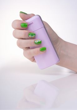 Female left hand with green manicure on a white table