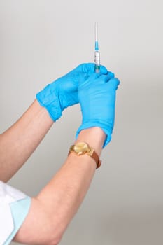 Hands keep the syringe with a needle in rubber medical gloves