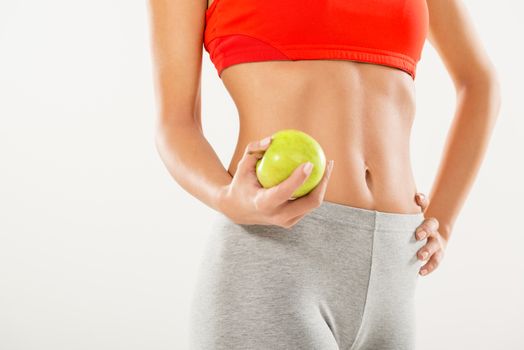 Perfect woman body. Woman holding apple. Dieting concept. White background.