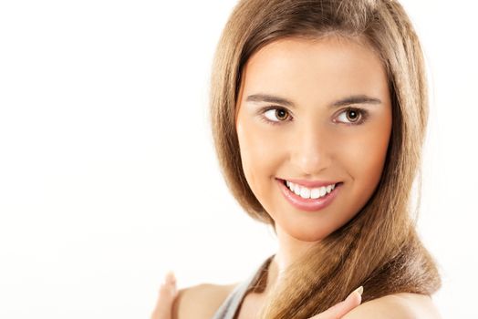 Close-up of beautiful smiling girl with brown hair and brown eyes.