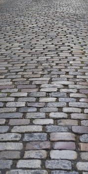 Old  traditional european style long narrow  cobblestone road background with granite blocks, stones and brickwork pattern