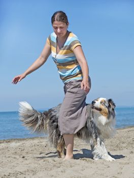 woman playing with her dog on the beach