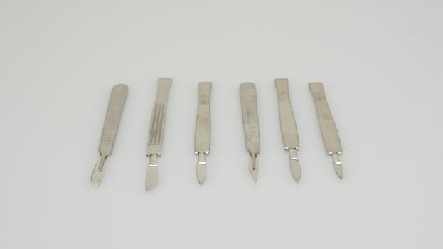 Many types of stainless scalpel were placed on white background.