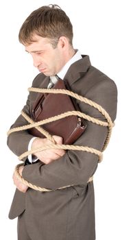 Young sad businessman and briefcase tied with ropes