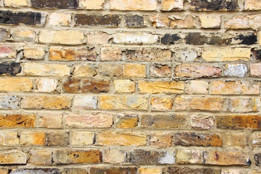 Old worn urban brick wall with different tiles