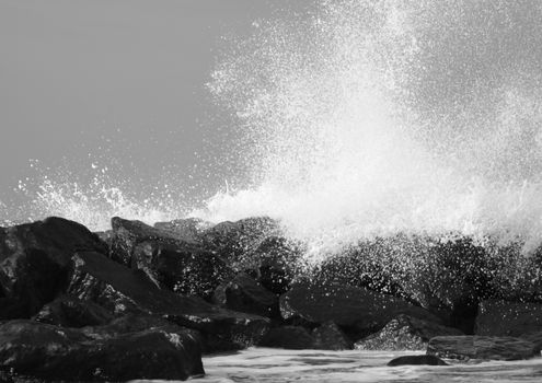 Crashing waves against black rocks at coast