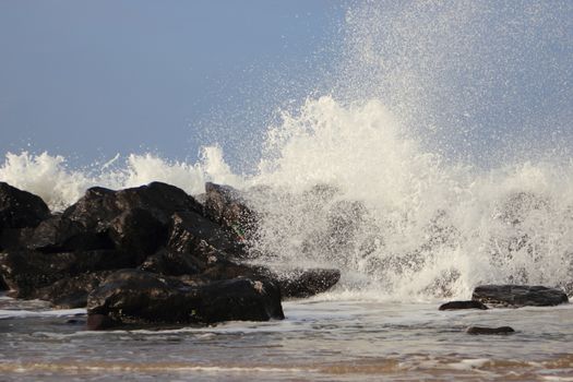 Crashing waves against black rocks at coast