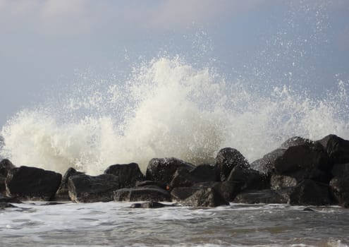 Crashing waves against black rocks at coast