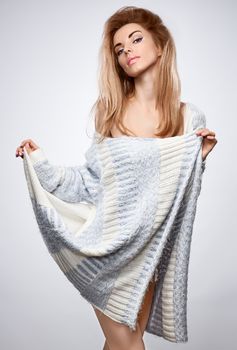 Beauty fashion portrait woman in stylish warm knitted sweater. Sensual attractive pretty blonde sexy model girl, shiny straight hair, confidence. Unusual creative provocative. Emotional playful people