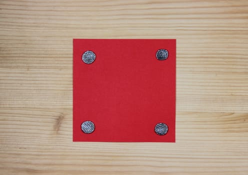 Red note attached to wood with nails