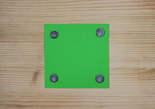 Green note attached to wood with nails