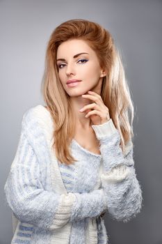 Beauty fashion portrait woman in stylish warm knitted sweater smiling. Sensual attractive pretty blonde sexy model girl, shiny straight hair. Unusual creative provocative. Emotional playful people