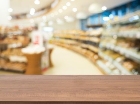 Wooden board empty table in front of blurred background. Perspective dark wood over blur in supermarket - can be used for display or montage your products. Mock up for display of product.