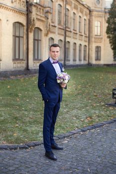 stylish trendy confident happy groom in blue bow  and cute suit