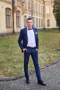 stylish trendy confident happy groom in blue bow  and cute suit