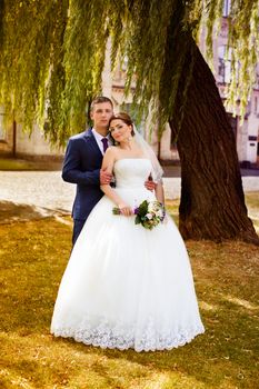 Happy newly-married couple in a park on a walk