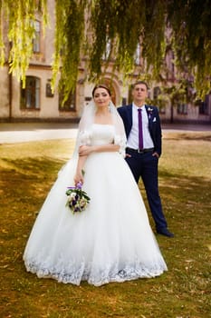 Happy newly-married couple in a park on a walk