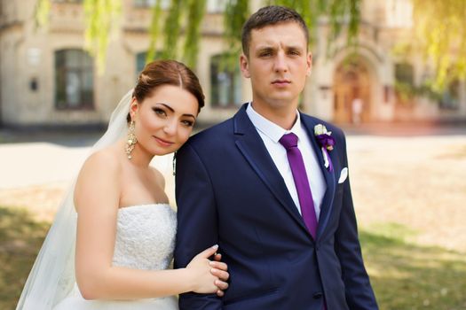 Happy newly-married couple in a park on a walk