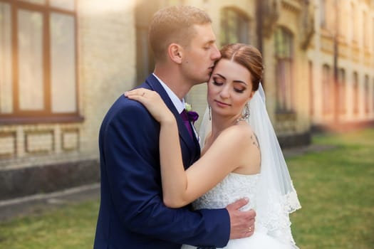 Happy newly-married couple in a park on a walk