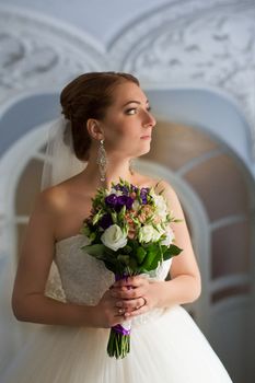 Portrait of a bride with red hair on the wedding day