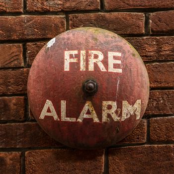 Rustic Vintage Fire Alarm Bell Against A Red Brick Wall
