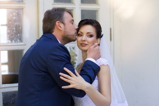 Wedding newlyweds kiss on a sunny day