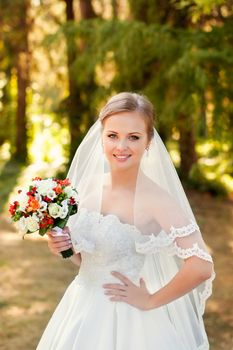 The bride in a white dress on a sunny day