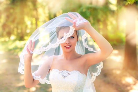 The bride in a white dress on a sunny day