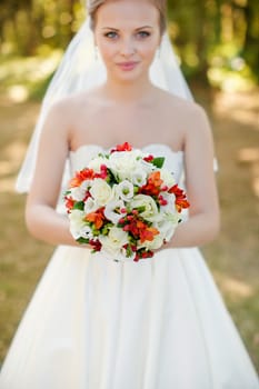 The bride in a white dress on a sunny day