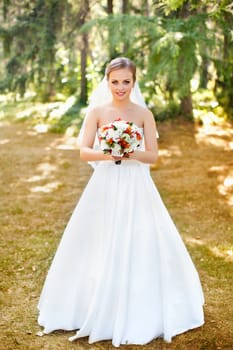 The bride in a white dress on a sunny day