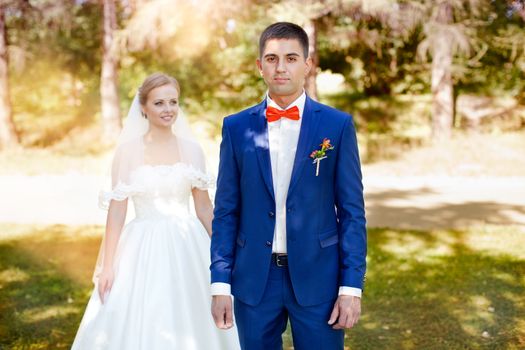 Funny bride and groom on a summer day in the park