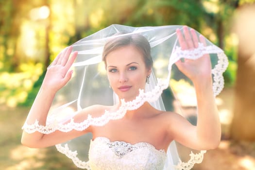 The bride in a white dress on a sunny day