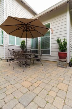 Garden Backyard with brick paver patio and furniture with table chairs and umbrella
