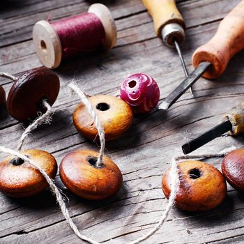 Accessories craft with wooden beads and tools on wooden background