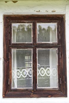 window with lace curtain of old traditional wooden polish cottage in open-air museum, Ethnographic Park, Kolbuszowa, Poland