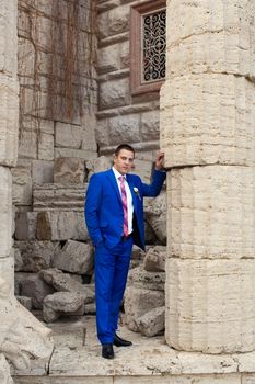 Elegant luxury wedding blue suit with bowtie on hanger tree closeup