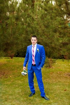 Elegant luxury wedding blue suit with bowtie on hanger tree closeup