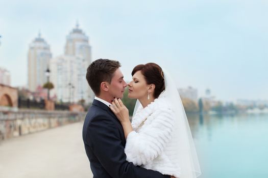 groom gently touched to the bride on a pier near the sea