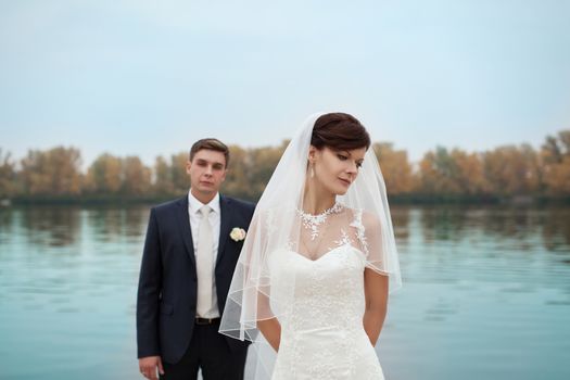 groom gently touched to the bride on a pier near the sea