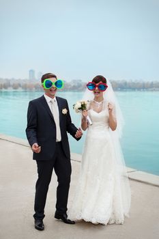 groom gently touched to the bride on a pier near the sea