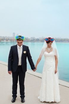 groom gently touched to the bride on a pier near the sea