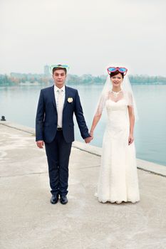 groom gently touched to the bride on a pier near the sea