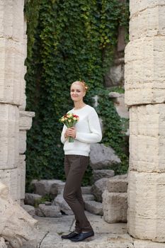 The blonde in a red jacket with a bouquet of flowers