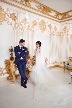 Stylish newlyweds posing for the camera in the apartment