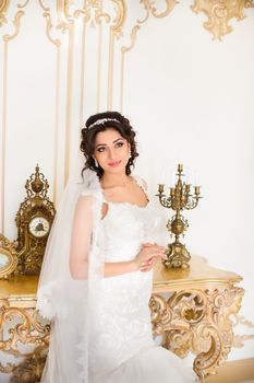 beautiful brunette bride in a luxurious wedding dress posing in interior