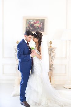 Stylish newlyweds posing for the camera in the apartment