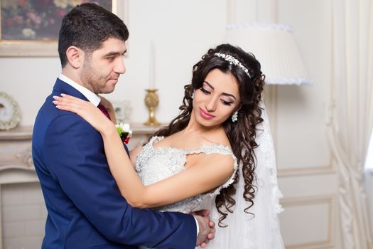 Stylish newlyweds posing for the camera in the apartment