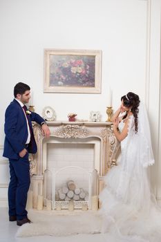 Stylish newlyweds posing for the camera in the apartment